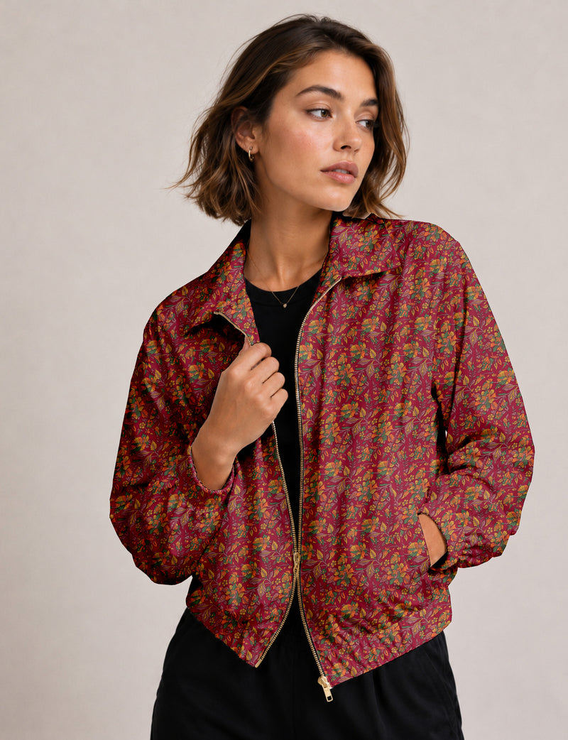 Woman wearing a yellow floral bomber jacket with front zipper, elastic cuffs, and side pockets, shown from front view