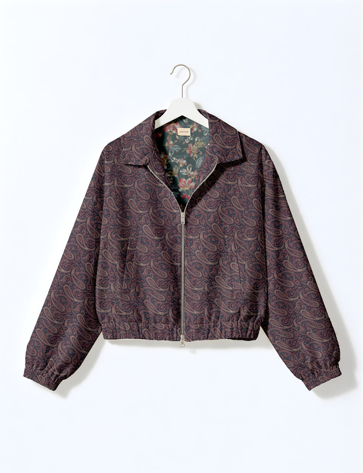 Brown floral bomber jacket with front zipper, elastic cuffs and hem, hanging on white hanger, red floral inner lining visible