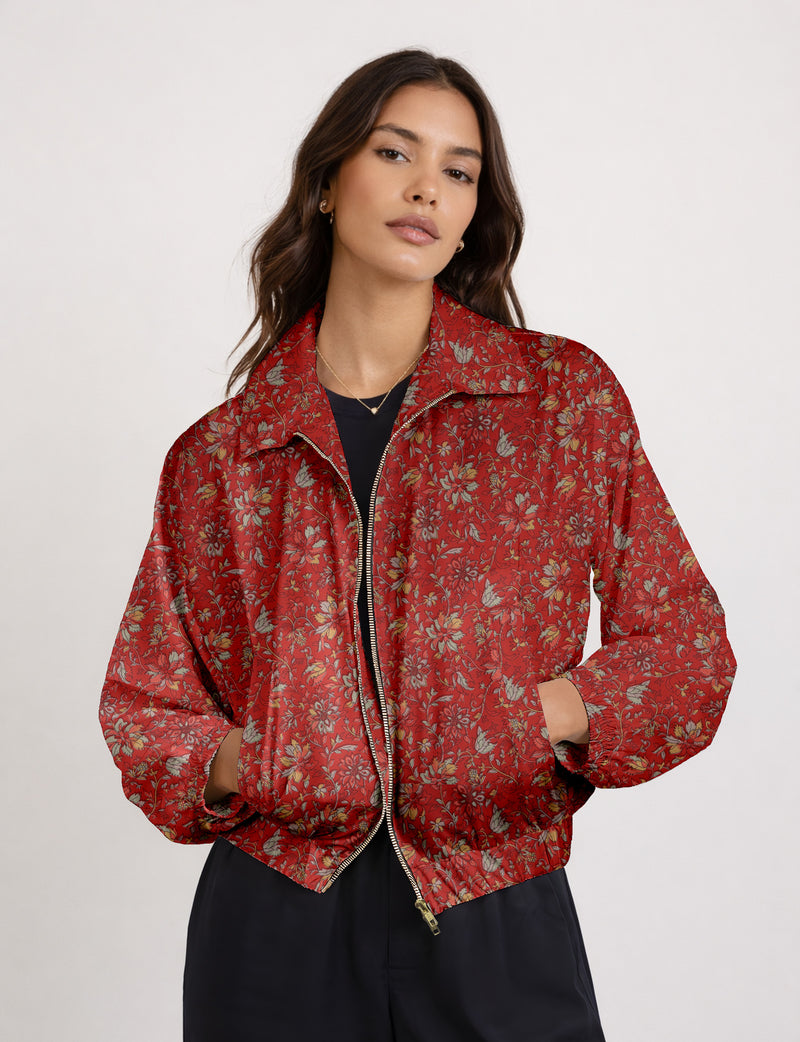 Brown floral bomber jacket with front zipper, elastic cuffs and hem, hanging on white hanger, red floral inner lining visible