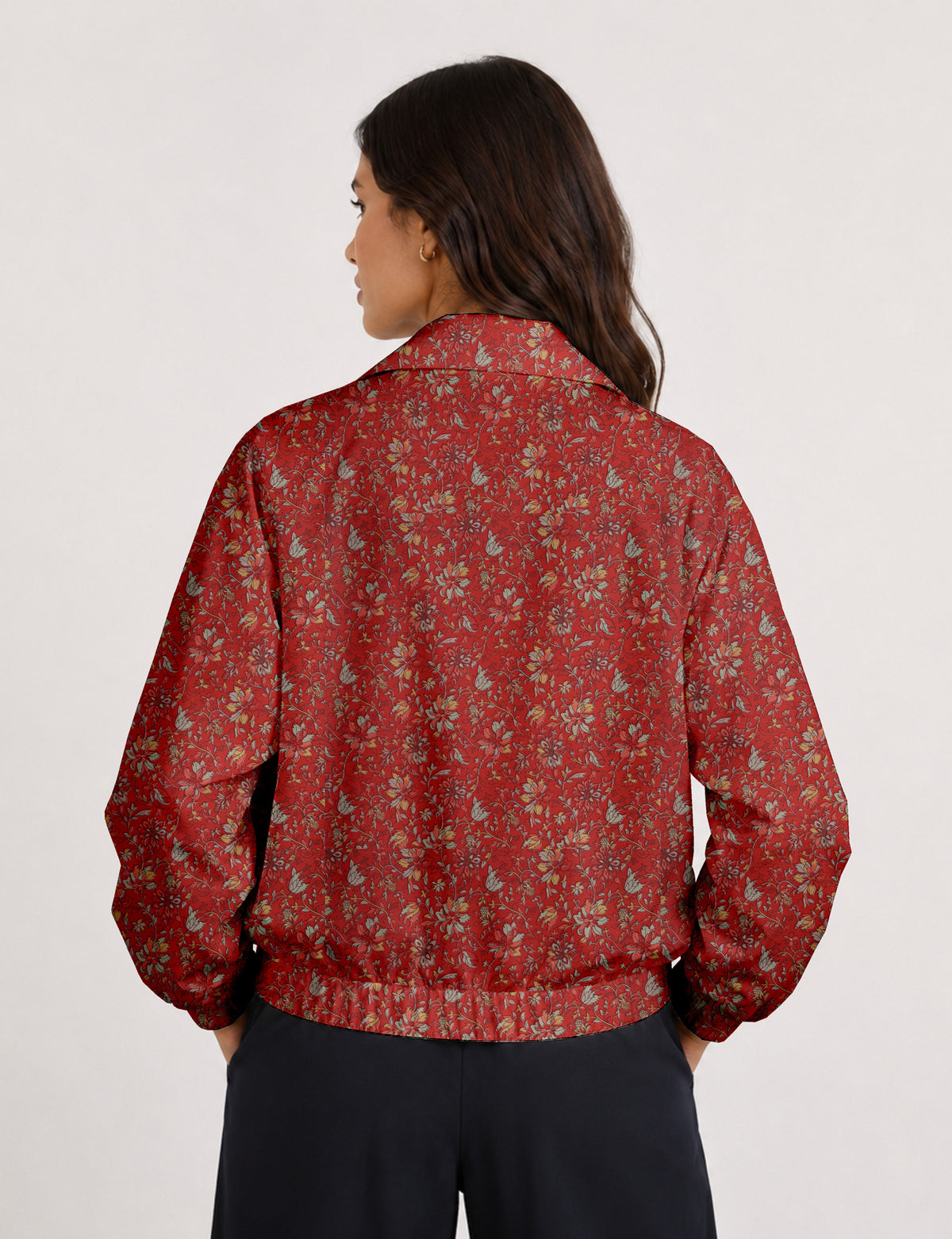 Woman wearing a yellow floral bomber jacket with front zipper, elastic cuffs, and side pockets, shown from front view