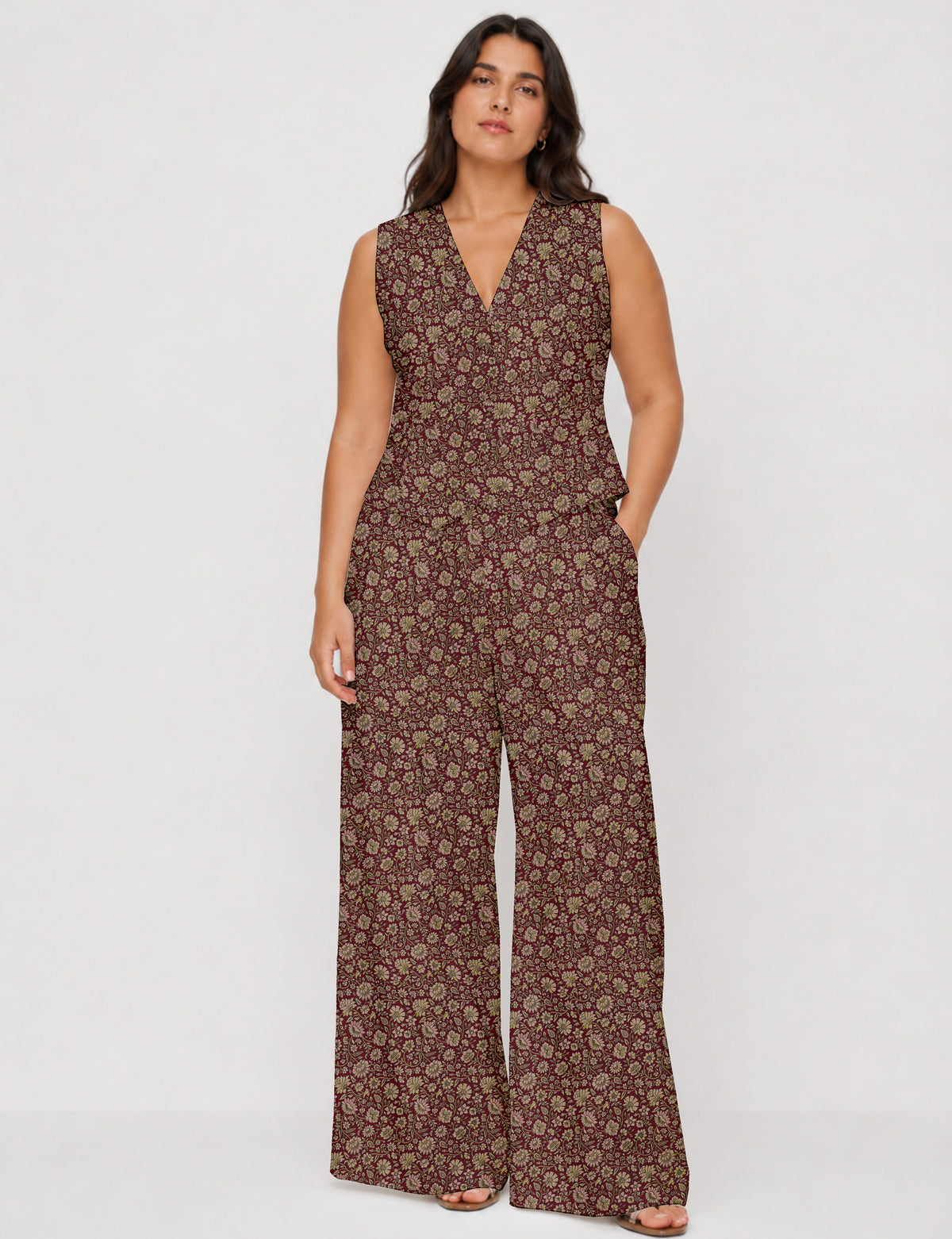 Woman wearing a sleeveless red floral waistcoat and matching wide-leg pants set, front view, hands in pockets