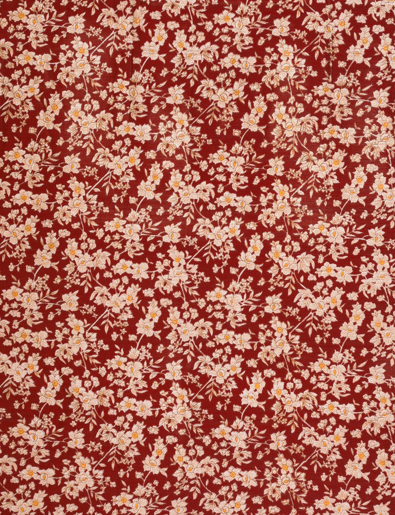 Red fabric with dense white and light pink floral print featuring small yellow centers and green leaves