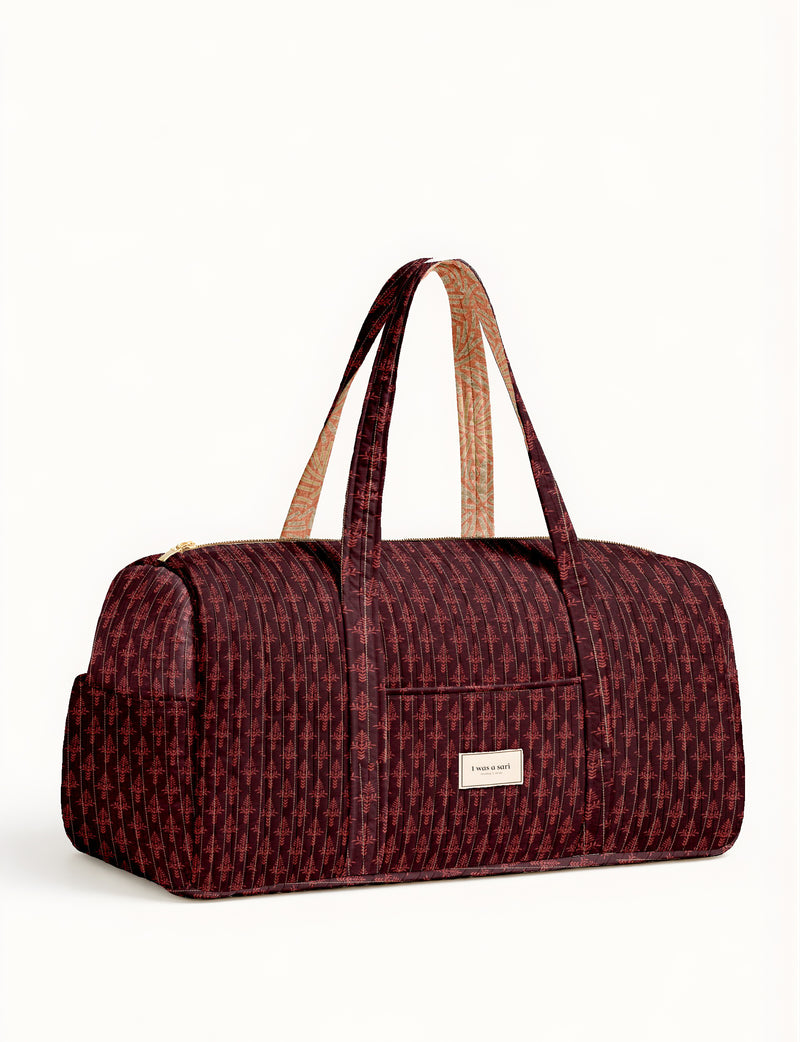 Twin travel duffle bag in dark red with micro pattern and dual handles, front pocket, and zipper closure