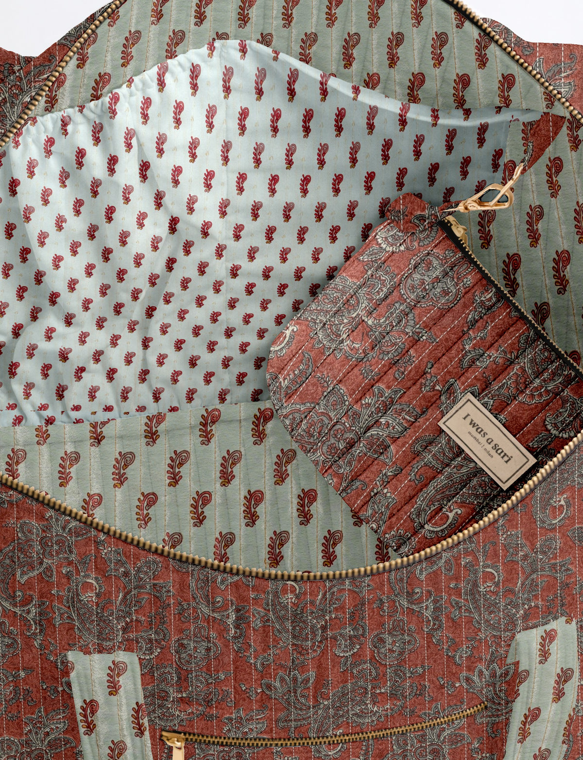 Quilted barrel bag in red paisley pattern with gold zipper and contrasting light blue interior lining with red motifs