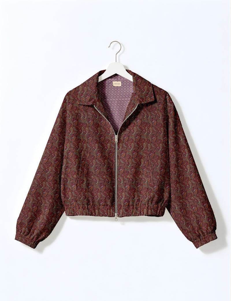 Brown floral bomber jacket with front zipper, elastic cuffs and hem, hanging on white hanger, red floral inner lining visible