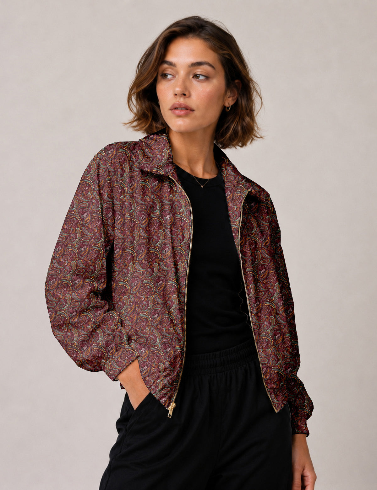 Brown floral bomber jacket with front zipper, elastic cuffs and hem, hanging on white hanger, red floral inner lining visible