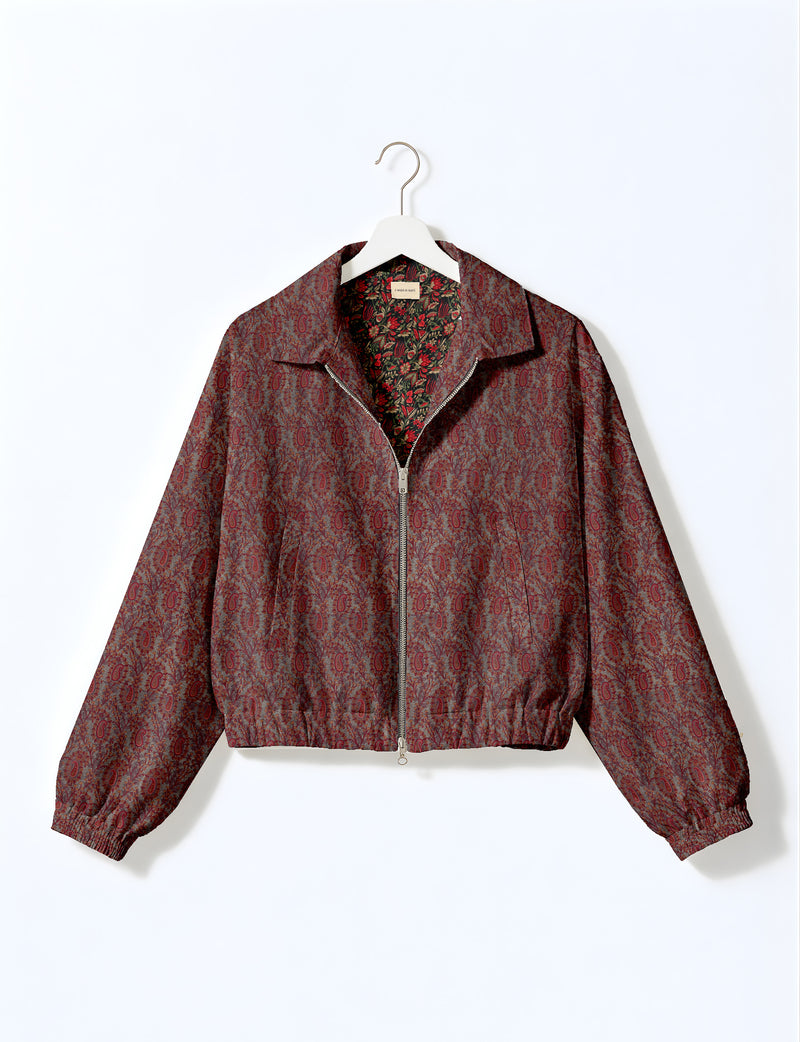 Brown floral bomber jacket with front zipper, elastic cuffs and hem, hanging on white hanger, red floral inner lining visible