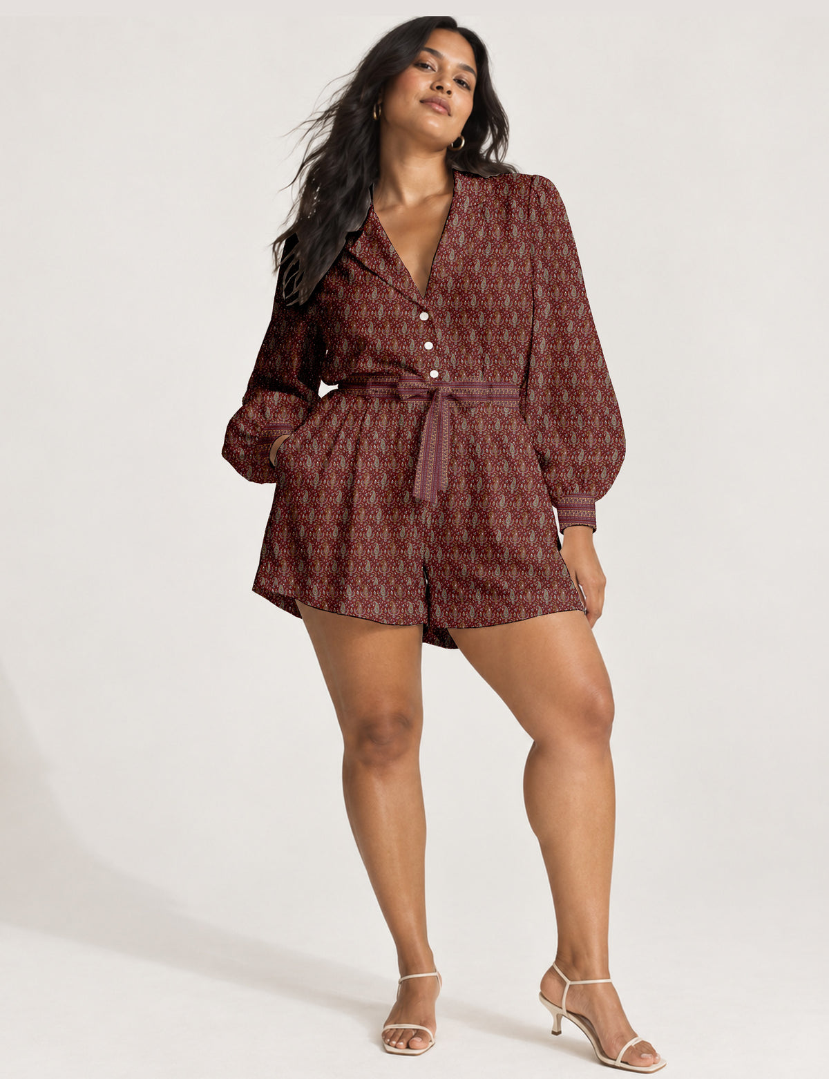 Women’s long sleeve playsuit with wrap-style front, V neckline, notched collar, adjustable waist tie and mid-thigh shorts.