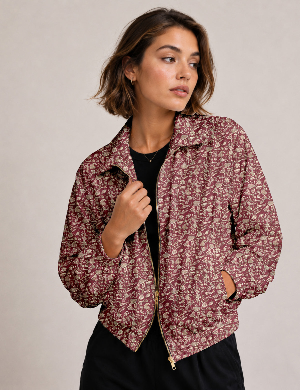 Woman wearing a yellow floral bomber jacket with front zipper, elastic cuffs, and side pockets, shown from front view