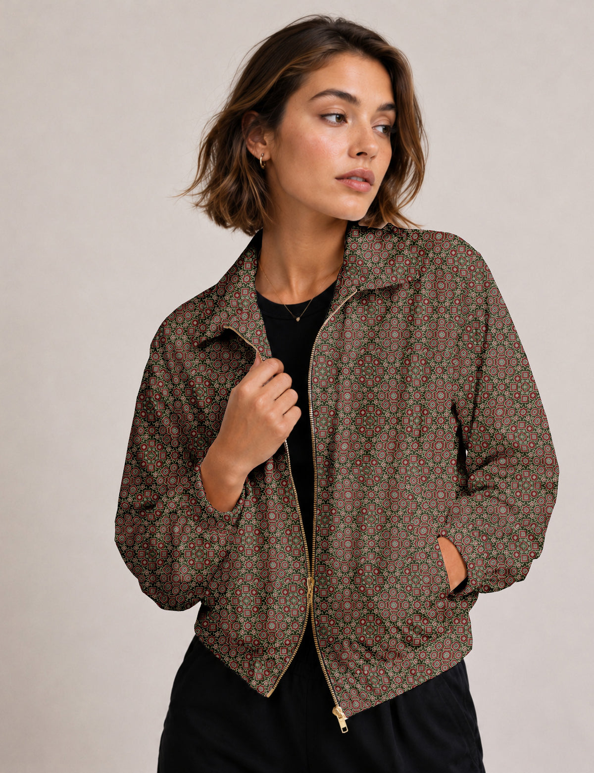 Brown floral bomber jacket with front zipper, elastic cuffs and hem, hanging on white hanger, red floral inner lining visible