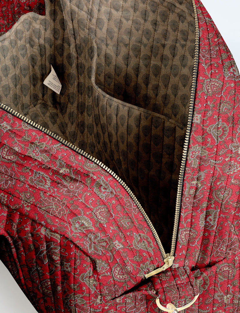 Brown quilted duffle bag with paisley pattern, front zip pocket, dual handles, and label reading "I was a sari"