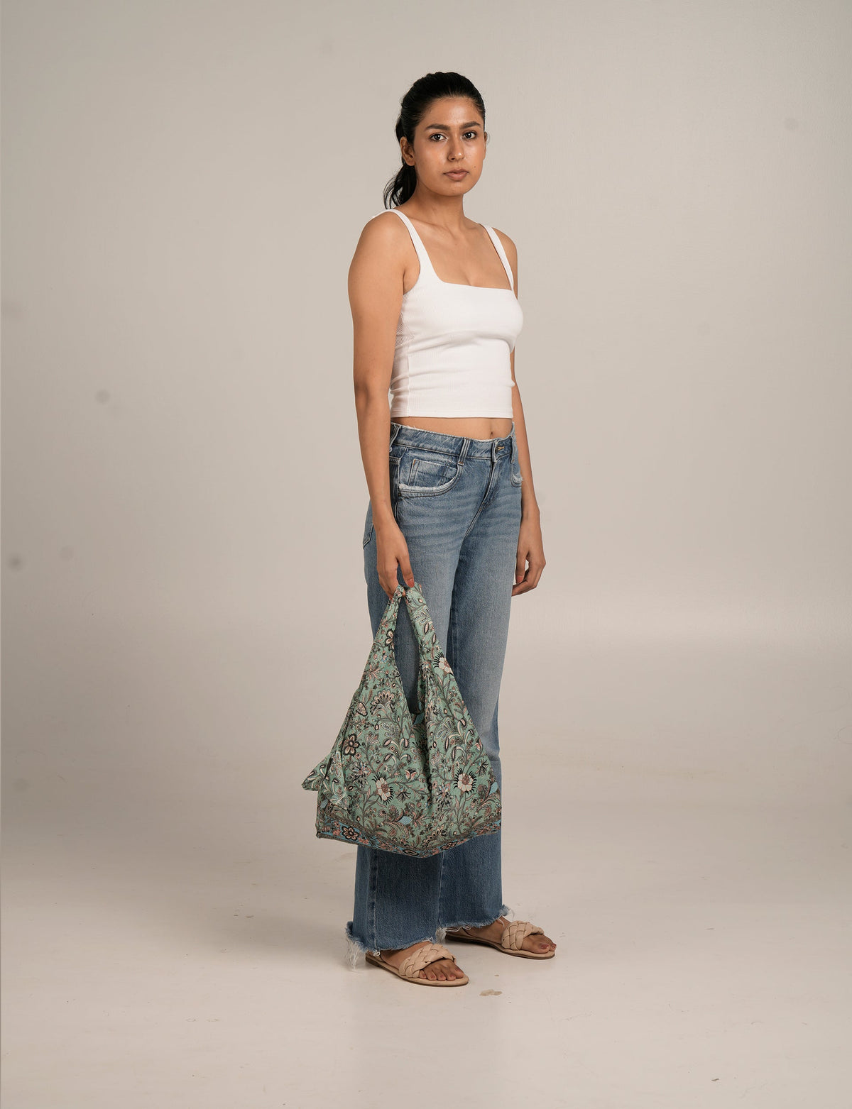 I was a Sari reusable bag in beige with floral design, featuring a soft fabric and spacious, slouchy style.
