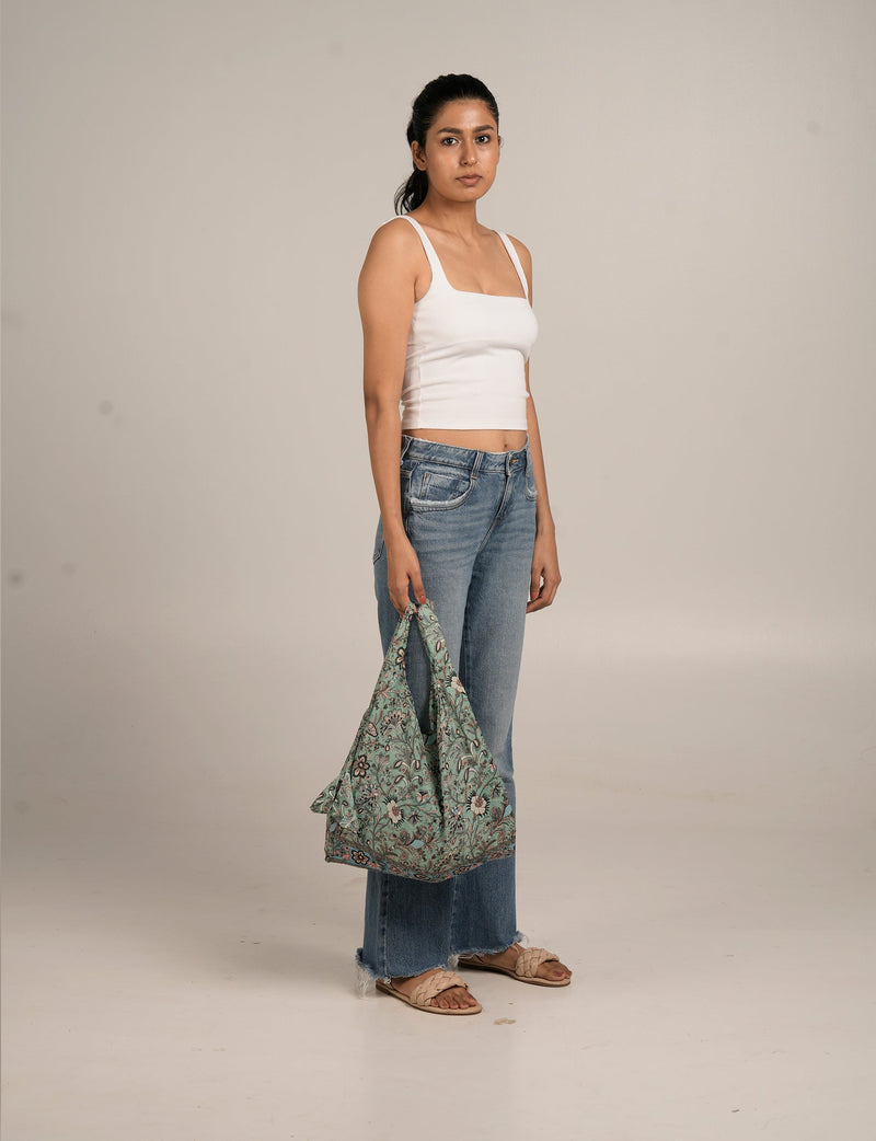 I was a Sari reusable bag in beige with floral design, featuring a soft fabric and spacious, slouchy style.