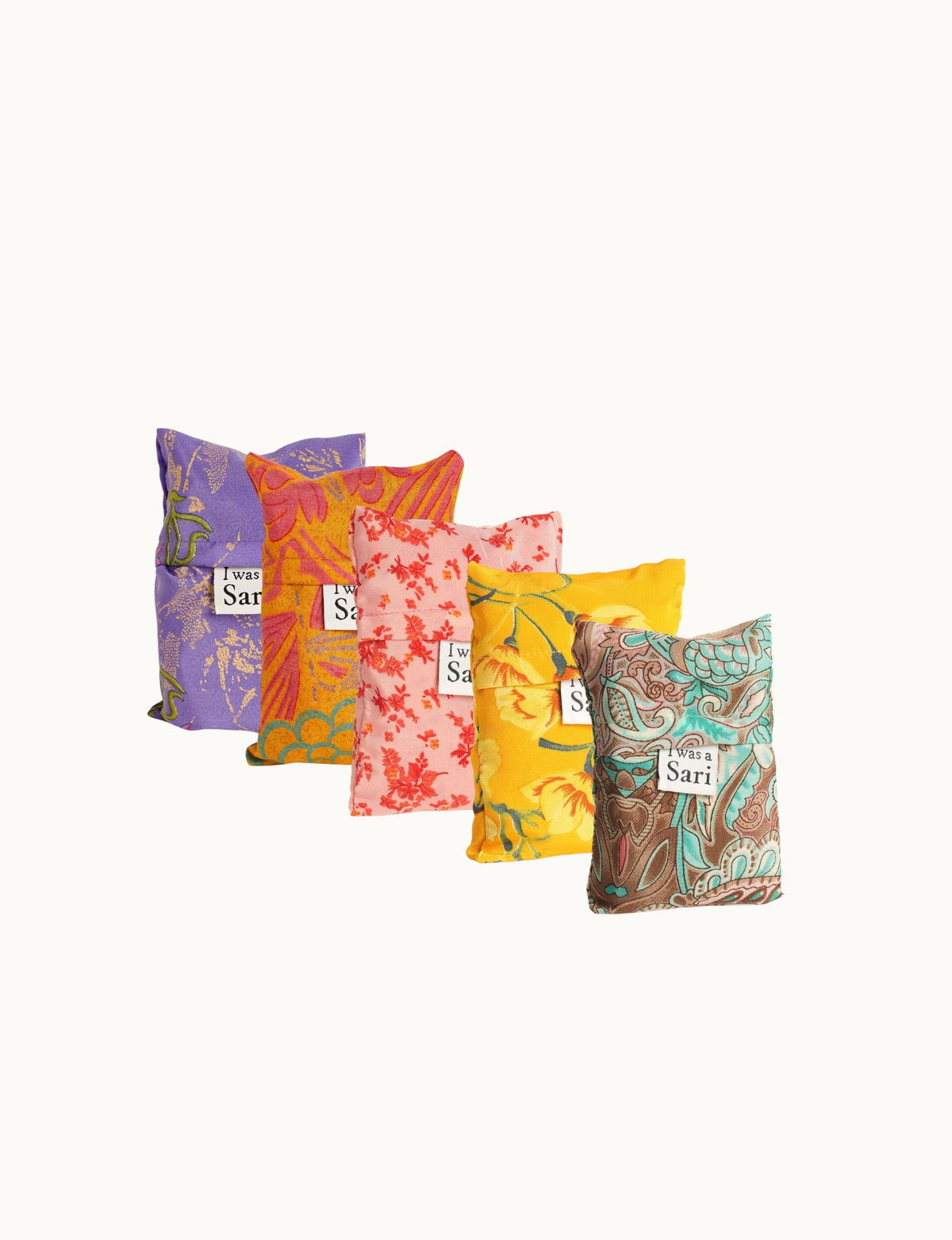 Set of five reusable fabric bags in purple, orange, pink, yellow, and teal floral patterns with "I was a Sari" labels