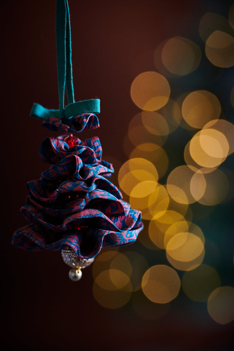 Fabric Christmas tree ornament in blue and red abstract pattern with green hanging loop and pearl detail at bottom