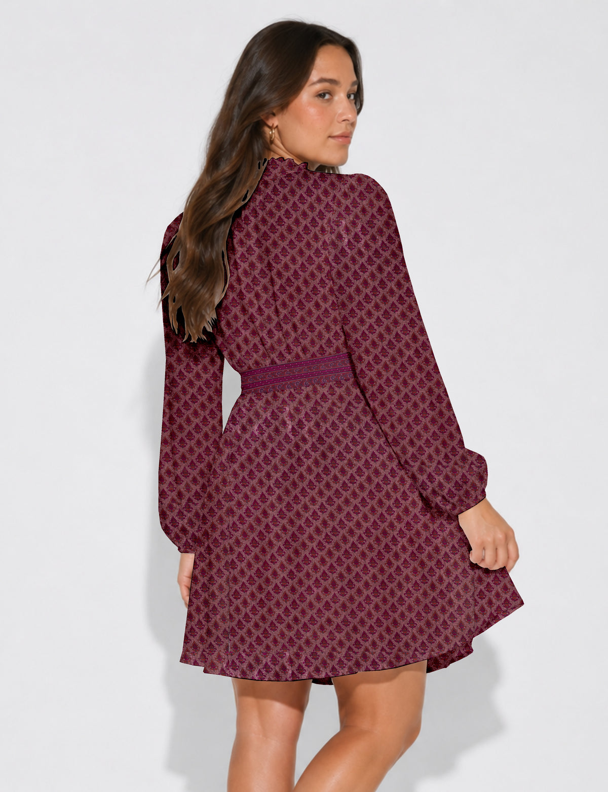 Woman wearing a pink swing dress with a leaf pattern, long sleeves, and a matching belt, shown from the back and side angle