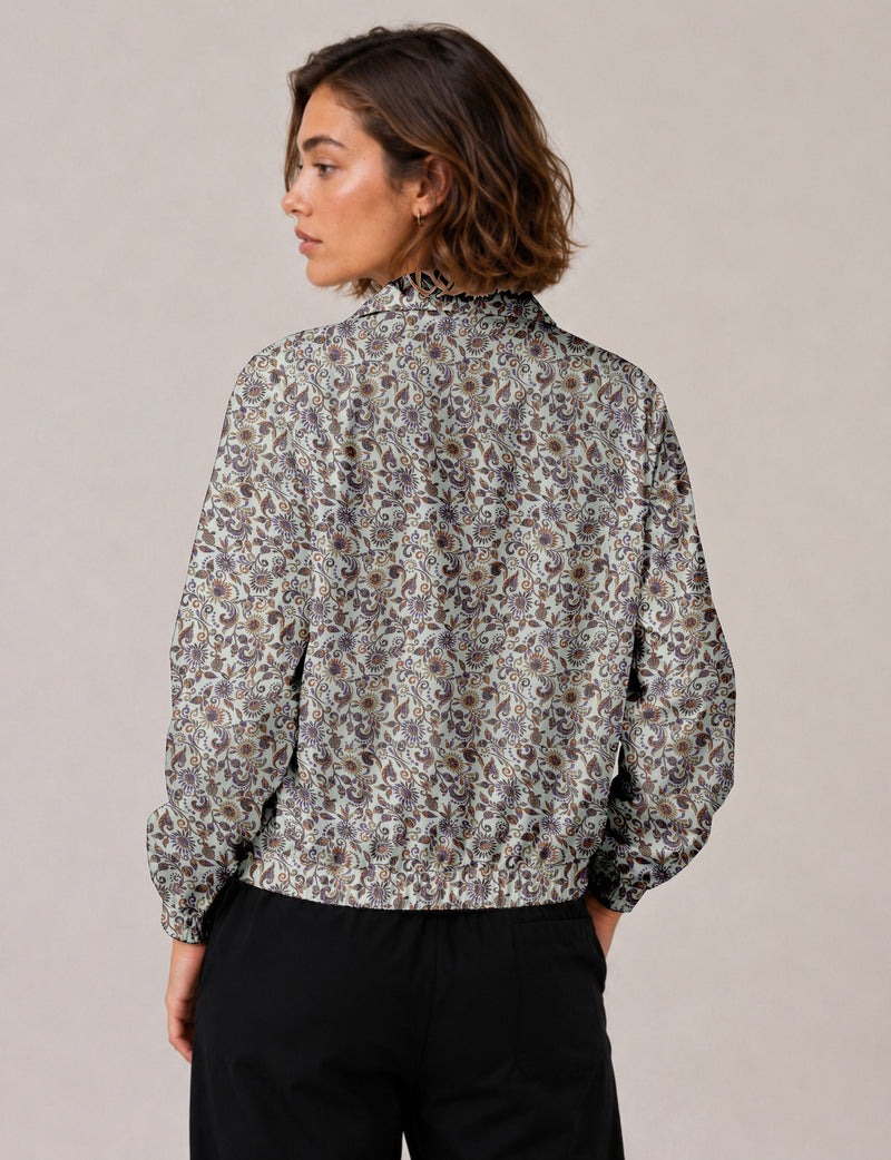 Brown floral bomber jacket with front zipper, elastic cuffs and hem, hanging on white hanger, red floral inner lining visible