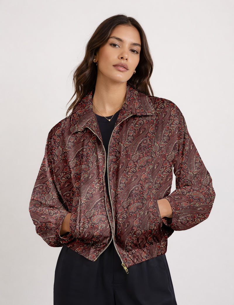 Woman wearing a yellow floral bomber jacket with front zipper, elastic cuffs, and side pockets, shown from front view