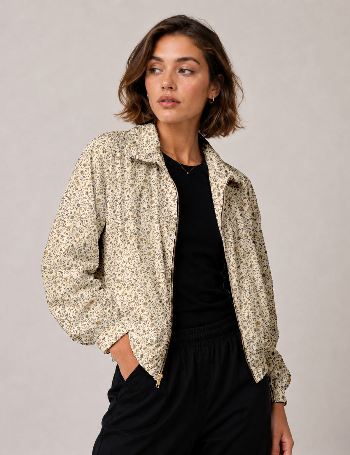Brown floral bomber jacket with front zipper, elastic cuffs and hem, hanging on white hanger, red floral inner lining visible