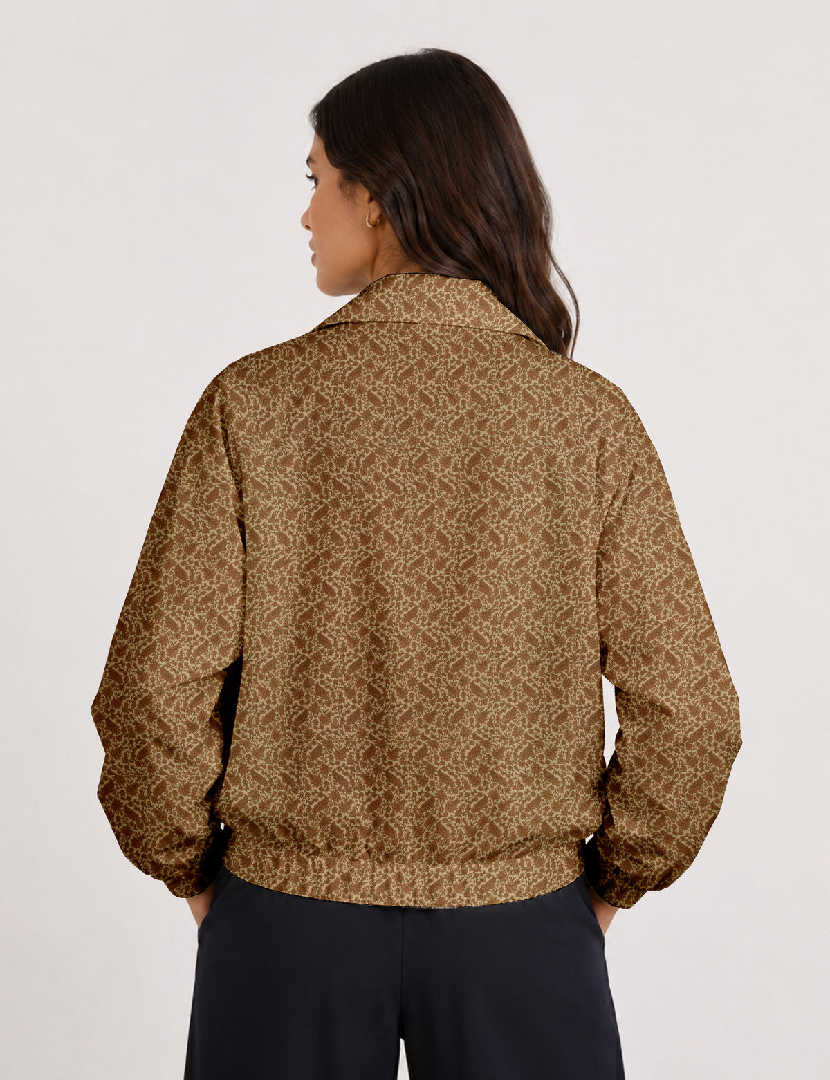 Brown floral bomber jacket with front zipper, elastic cuffs and hem, hanging on white hanger, red floral inner lining visible