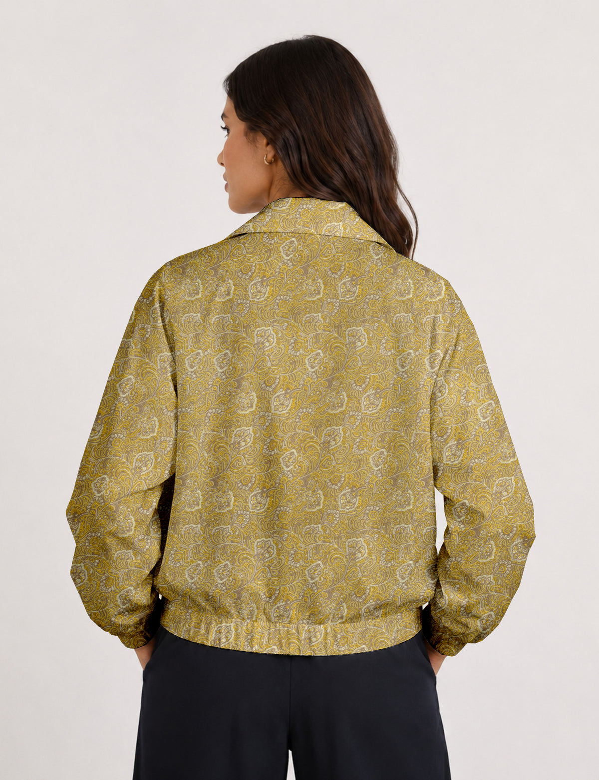 Brown floral bomber jacket with front zipper, elastic cuffs and hem, hanging on white hanger, red floral inner lining visible