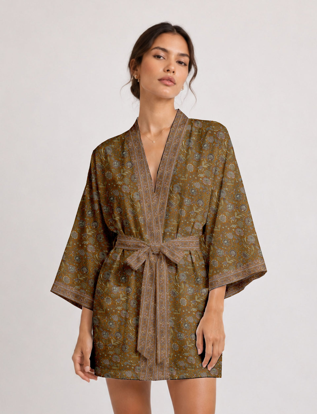Woman wearing a short brown floral kimono robe with wide sleeves and a matching fabric belt tied at the waist
