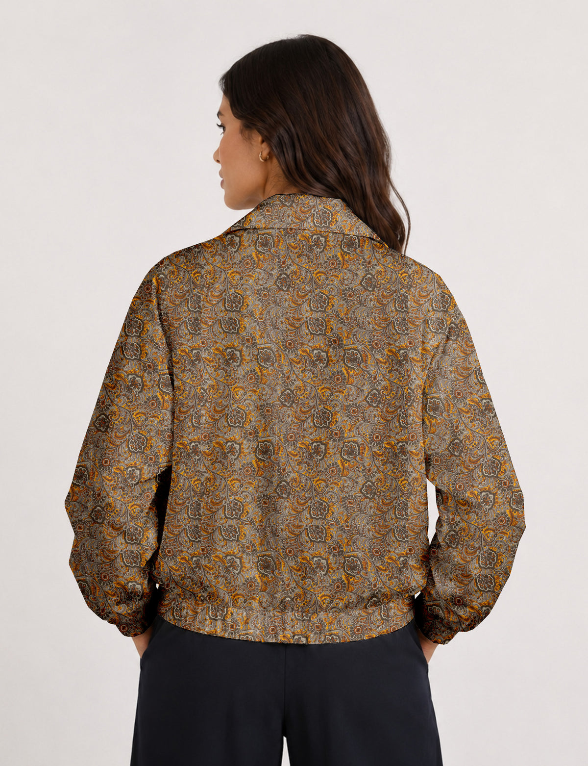 Woman wearing a yellow floral bomber jacket with front zipper, elastic cuffs, and side pockets, shown from front view