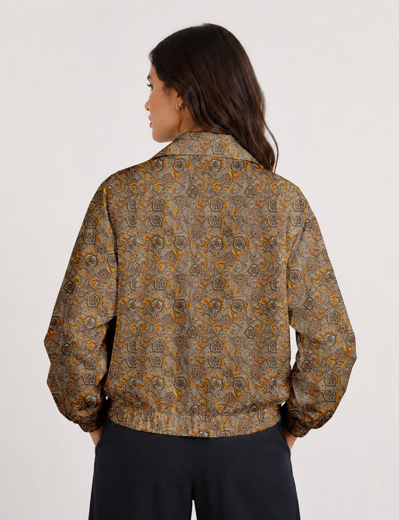 Woman wearing a yellow floral bomber jacket with front zipper, elastic cuffs, and side pockets, shown from front view