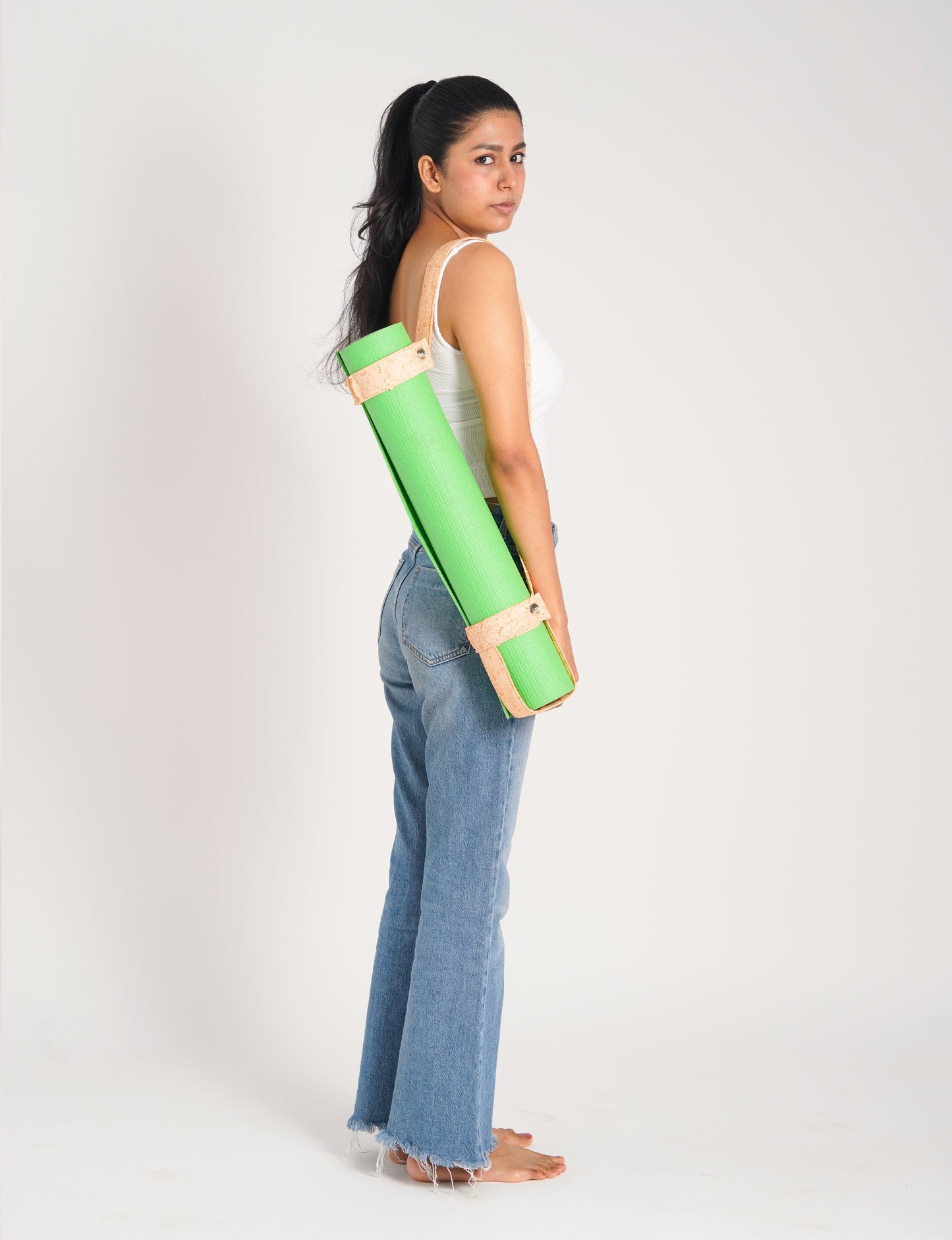 A green yoga mat holder made from upcycled materials, embodying ethical and sustainable fashion ideals.