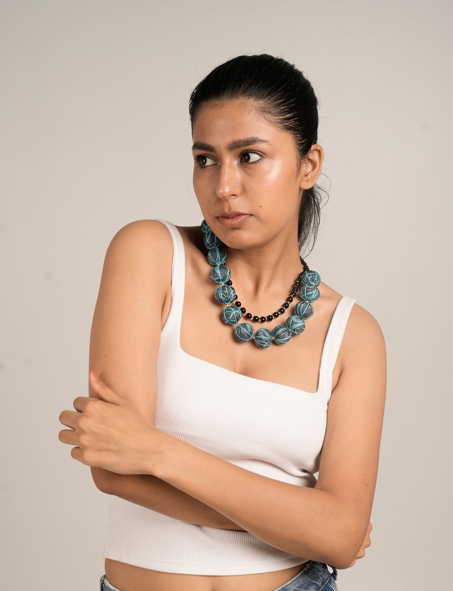 Make a sustainable statement with our UP-CYCLED DOUBLE BEADED CHOKER. Muskmelon-inspired beads, upcycled from waste fabric and hand-wrapped in pre-loved saris, create a unique blend. Small glass beads add elegance. Hypoallergy tested metal hooks, skin-friendly, nickel, and lead-free. Explore the world of upcycled fashion.