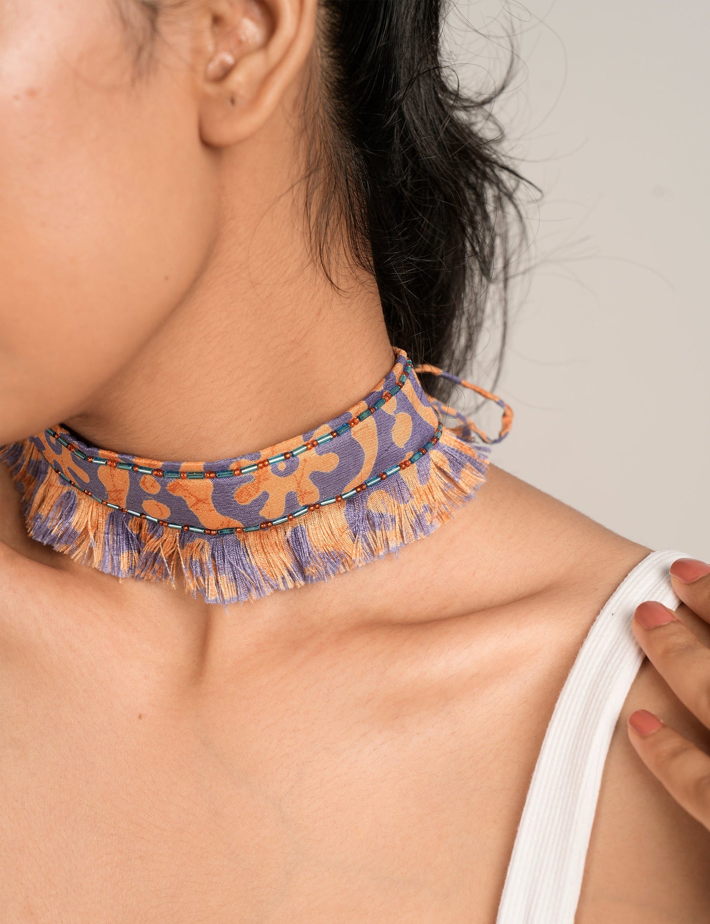 Discover the charm of our Tie-Up Fringe Choker, a meticulously crafted necklace with sari fringe edging and a tie-up back. Adorned with Indian salli beads by skilled female artisans in Mumbai, this accessory embodies ethical fashion and sustainable elegance.