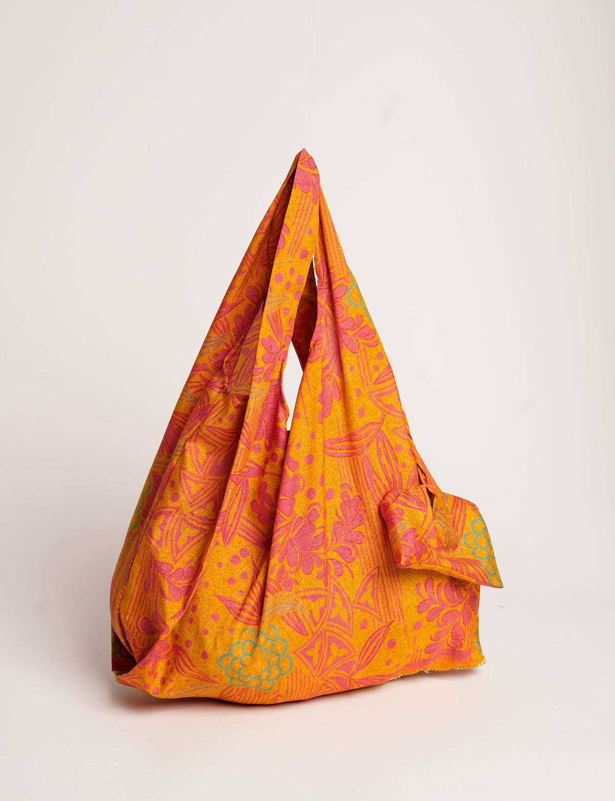 Stay eco-conscious with our Reusable Bag, handmade by Indian artisans from pre-loved saris. Silky and lightweight, this foldaway bag is perfect for your on-the-go lifestyle. Each piece is a unique statement of ethical fashion, embracing sustainability and style.