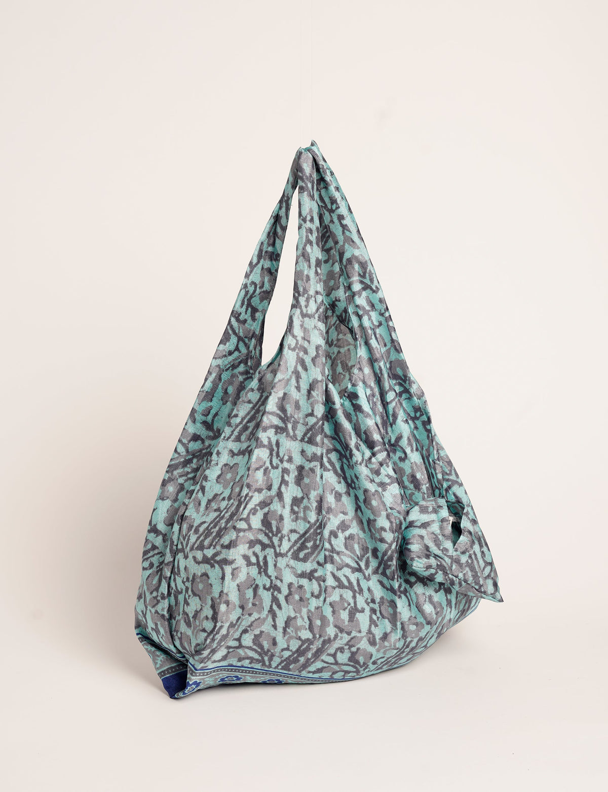 Stay eco-conscious with our Reusable Bag, handmade by Indian artisans from pre-loved saris. Silky and lightweight, this foldaway bag is perfect for your on-the-go lifestyle. Each piece is a unique statement of ethical fashion, embracing sustainability and style.