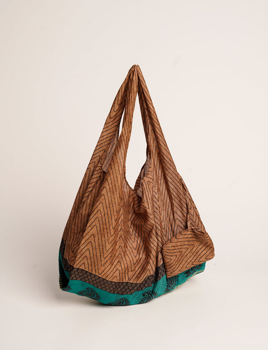 Stay eco-conscious with our Reusable Bag, handmade by Indian artisans from pre-loved saris. Silky and lightweight, this foldaway bag is perfect for your on-the-go lifestyle. Each piece is a unique statement of ethical fashion, embracing sustainability and style.