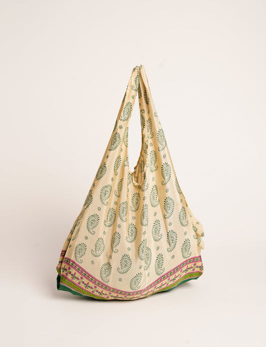 Stay eco-conscious with our Reusable Bag, handmade by Indian artisans from pre-loved saris. Silky and lightweight, this foldaway bag is perfect for your on-the-go lifestyle. Each piece is a unique statement of ethical fashion, embracing sustainability and style.
