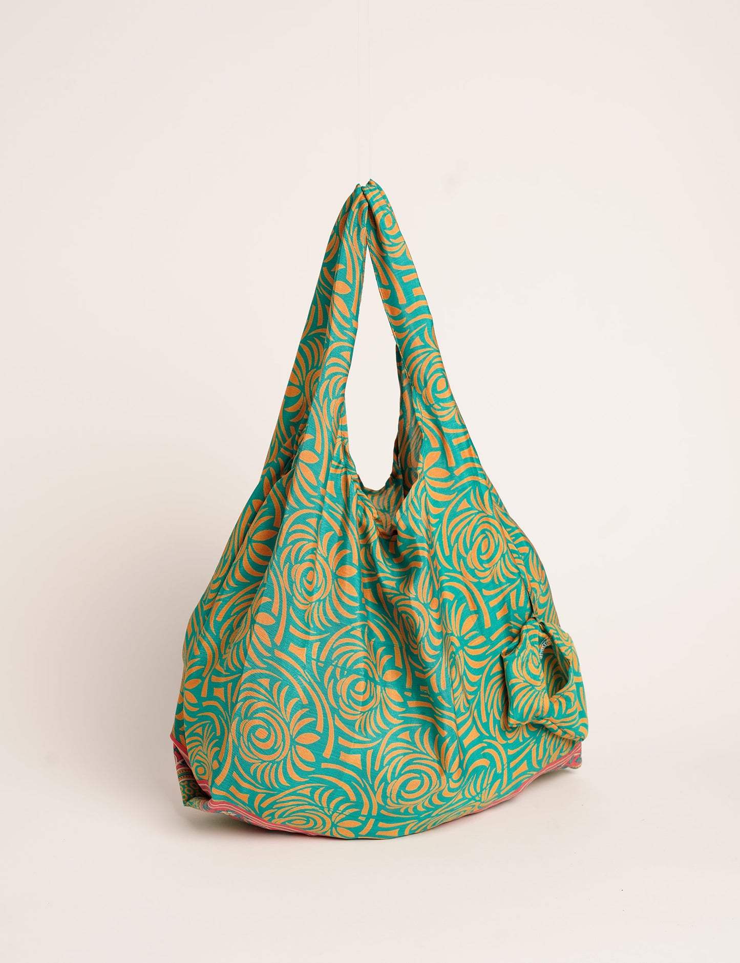 Stay eco-conscious with our Reusable Bag, handmade by Indian artisans from pre-loved saris. Silky and lightweight, this foldaway bag is perfect for your on-the-go lifestyle. Each piece is a unique statement of ethical fashion, embracing sustainability and style.