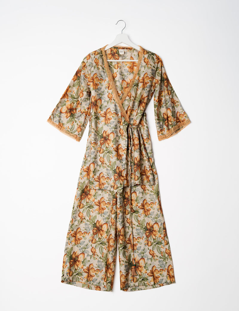 Beige floral tunic set with wrap front, lace trim, and wide-leg pants hanging on white hanger against white background