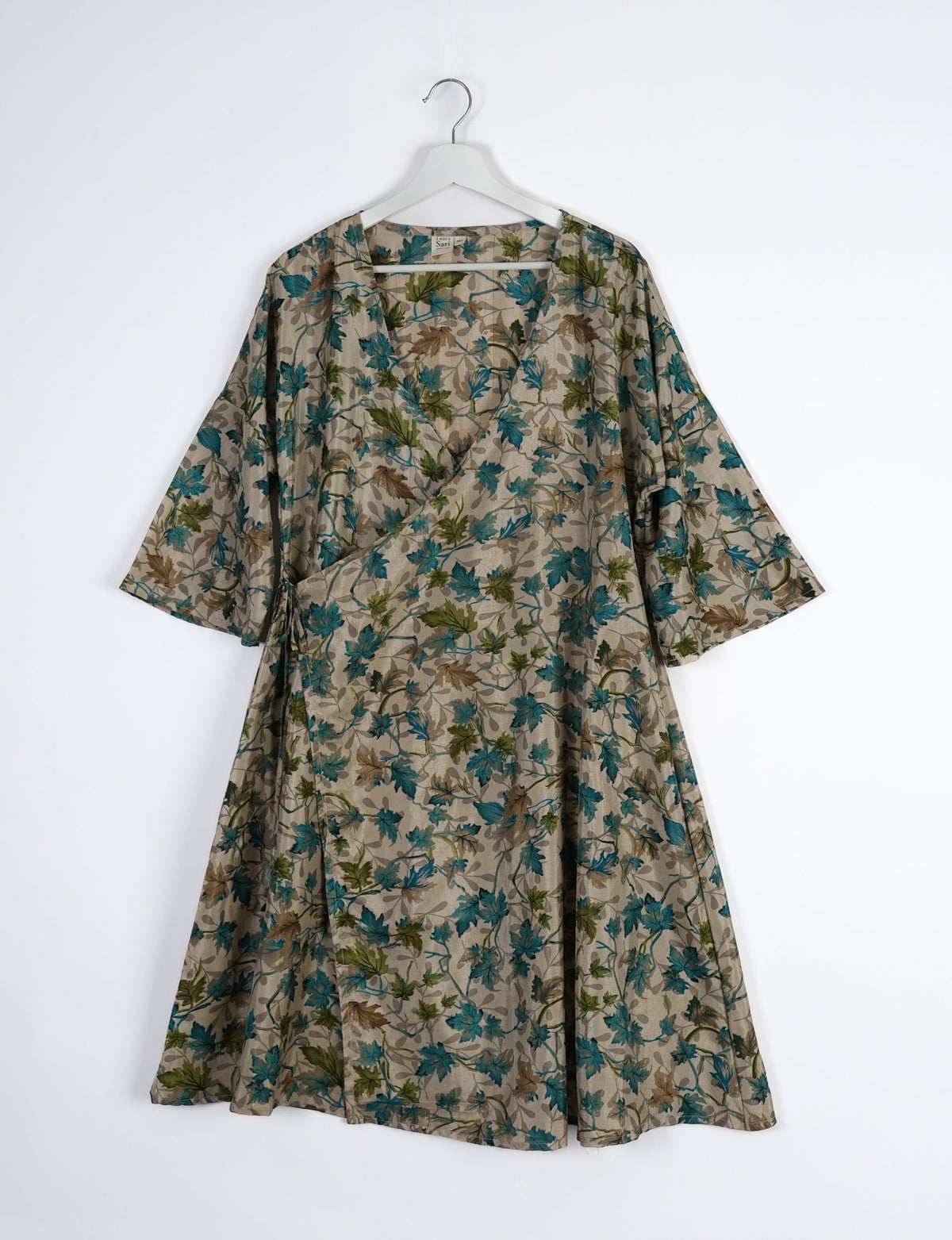 Elevate your style with our Sunset Coat, a shin-length wrap featuring a deep V-neck, wide flared 3/4 sleeves, and side tie with thread tassels. Embrace ethical and sustainable fashion with this zero waste, upcycled garment. A perfect blend of elegance and whimsy for conscious clothing enthusiasts.