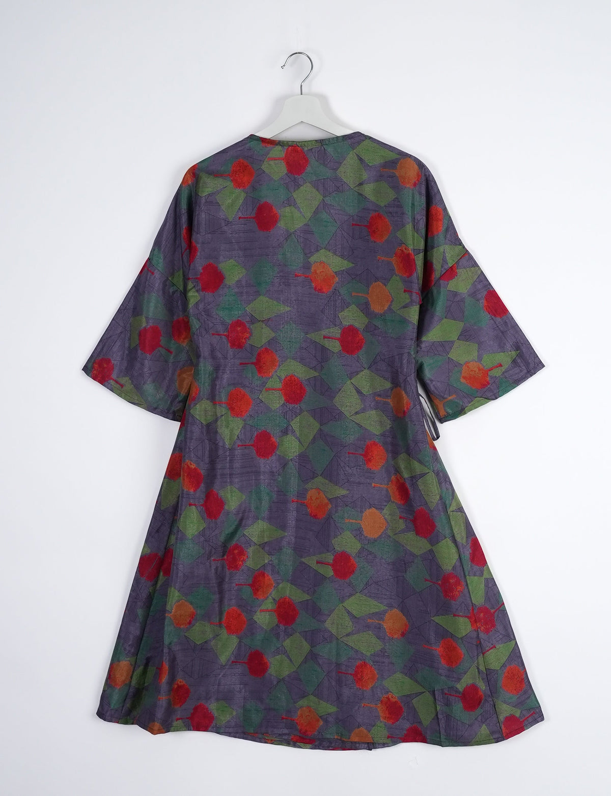 Elevate your style with our Sunset Coat, a shin-length wrap featuring a deep V-neck, wide flared 3/4 sleeves, and side tie with thread tassels. Embrace ethical and sustainable fashion with this zero waste, upcycled garment. A perfect blend of elegance and whimsy for conscious clothing enthusiasts.