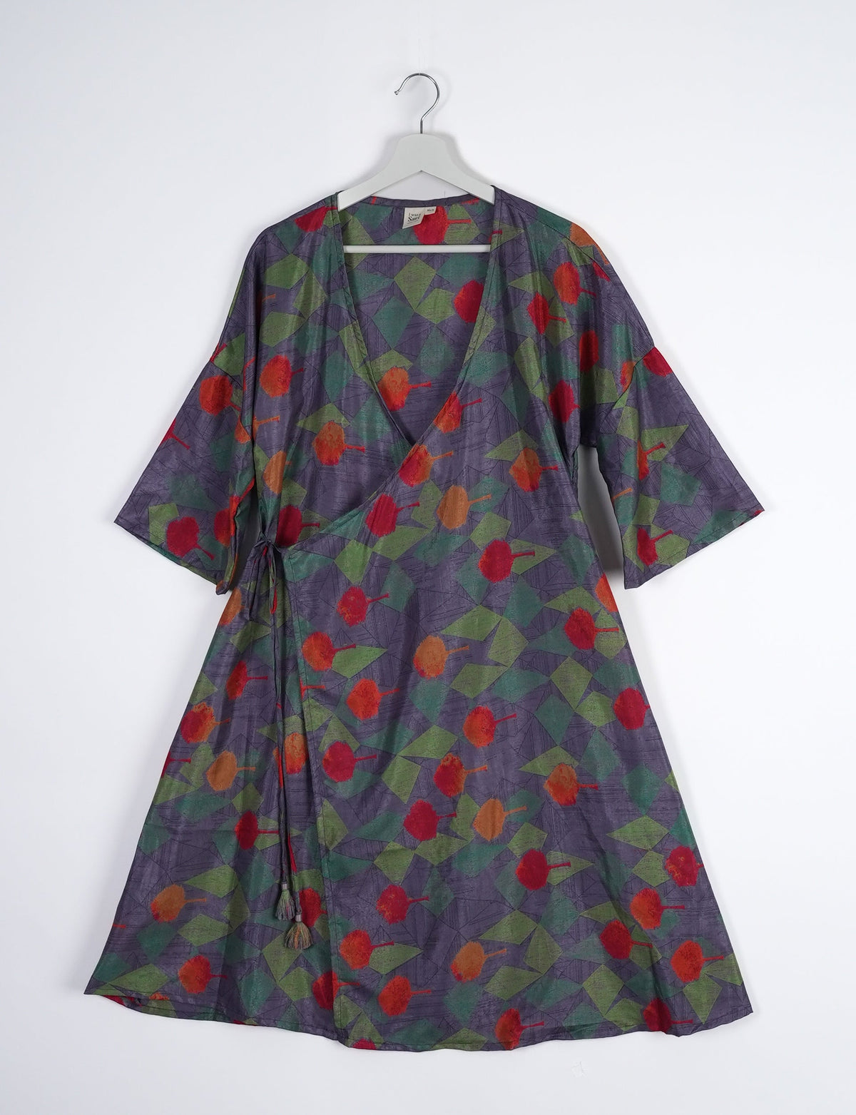 Elevate your style with our Sunset Coat, a shin-length wrap featuring a deep V-neck, wide flared 3/4 sleeves, and side tie with thread tassels. Embrace ethical and sustainable fashion with this zero waste, upcycled garment. A perfect blend of elegance and whimsy for conscious clothing enthusiasts.