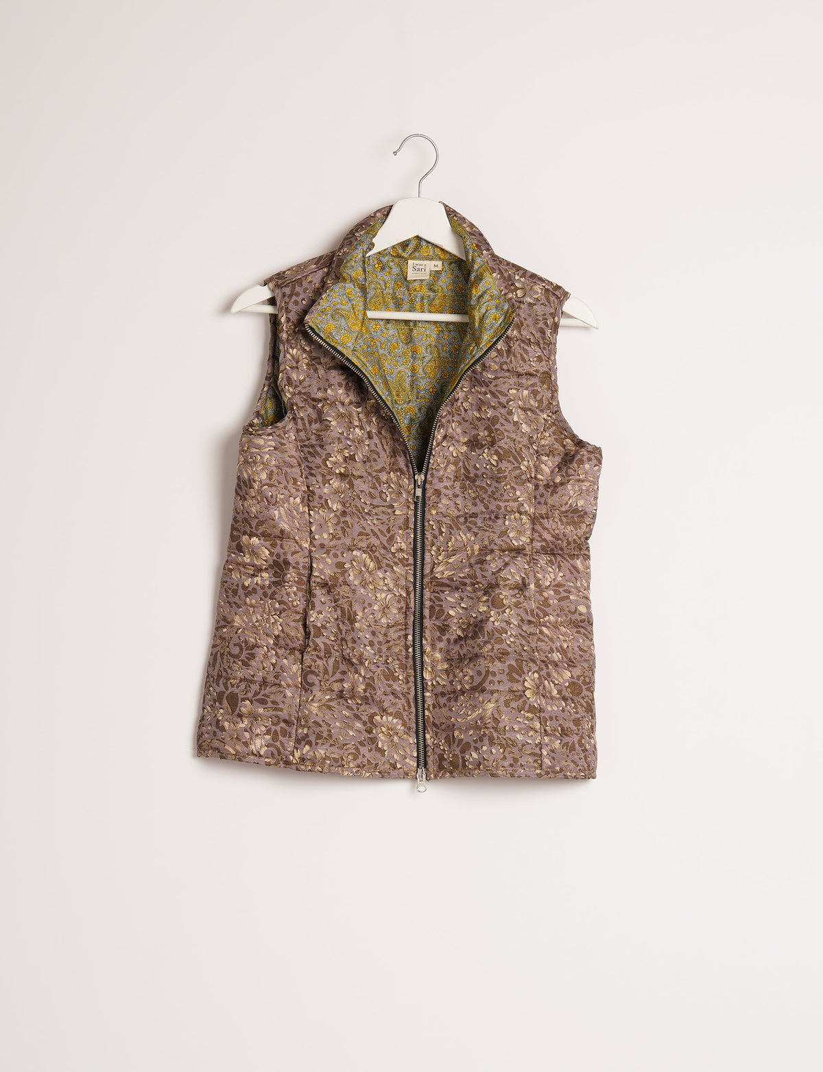 Elevate your style with our QUILTED GILET, crafted from upcycled tropical saris. This sleeveless jacket, with its quilted warmth, is perfect for layering over tees or sweaters. Choose ethical, green fashion and experience the comfort of sustainable living with a touch of home.