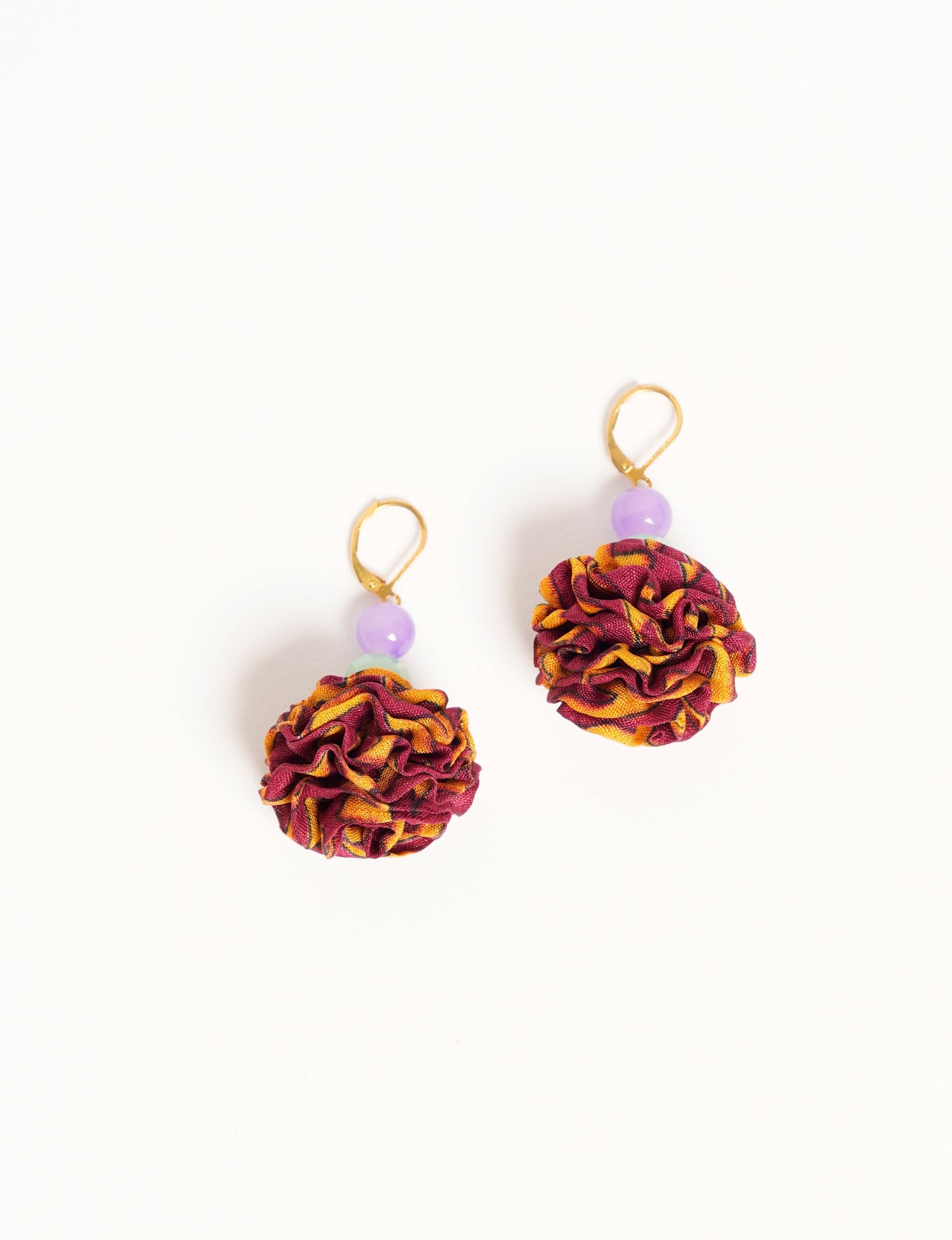Elevate your style with our Ruffle Earrings, adorned with unique ruffle ball florets crafted from upcycled Indian saris using the traditional Aari embroidery technique. These sustainable earrings feature two glass beads and nickel-free, hypoallergenic metal hooks. Embrace ethical and green fashion with these statement pieces.