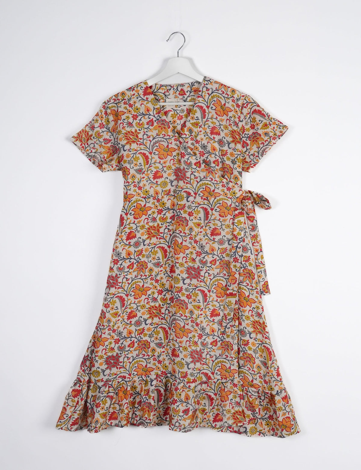 Embrace timeless elegance with our MIDI WRAP DRESS – a midi-length beauty featuring a v-neck, flattery from all angles, and a charming sari belt. Crafted from sustainable materials, this dress embodies ethical clothing and green fashion. Sophisticated with a frill tier at the hem and short cap sleeves, this dress is perfect for any occasion. Tie up the beautifully crafted sari belt on the side for a versatile, stylish, and eco-friendly look.