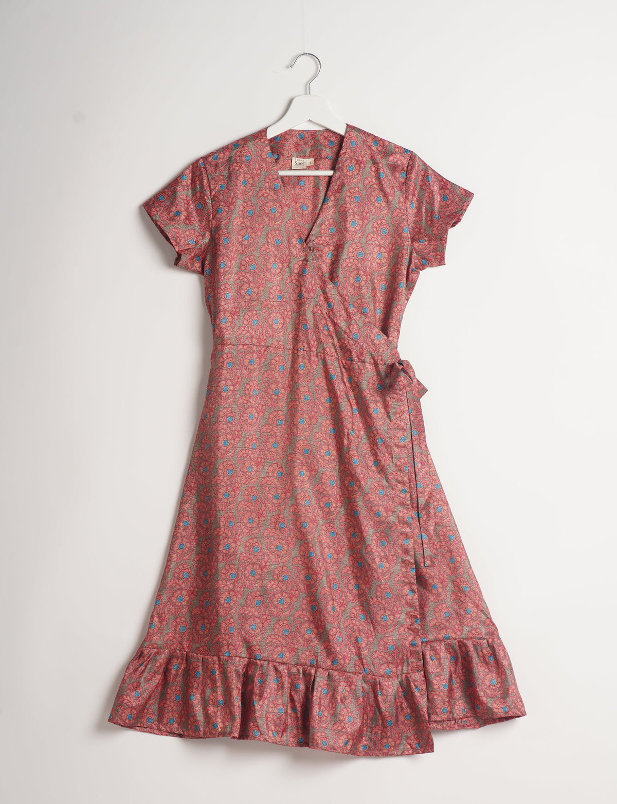 Embrace timeless elegance with our MIDI WRAP DRESS – a midi-length beauty featuring a v-neck, flattery from all angles, and a charming sari belt. Crafted from sustainable materials, this dress embodies ethical clothing and green fashion. Sophisticated with a frill tier at the hem and short cap sleeves, this dress is perfect for any occasion. Tie up the beautifully crafted sari belt on the side for a versatile, stylish, and eco-friendly look.