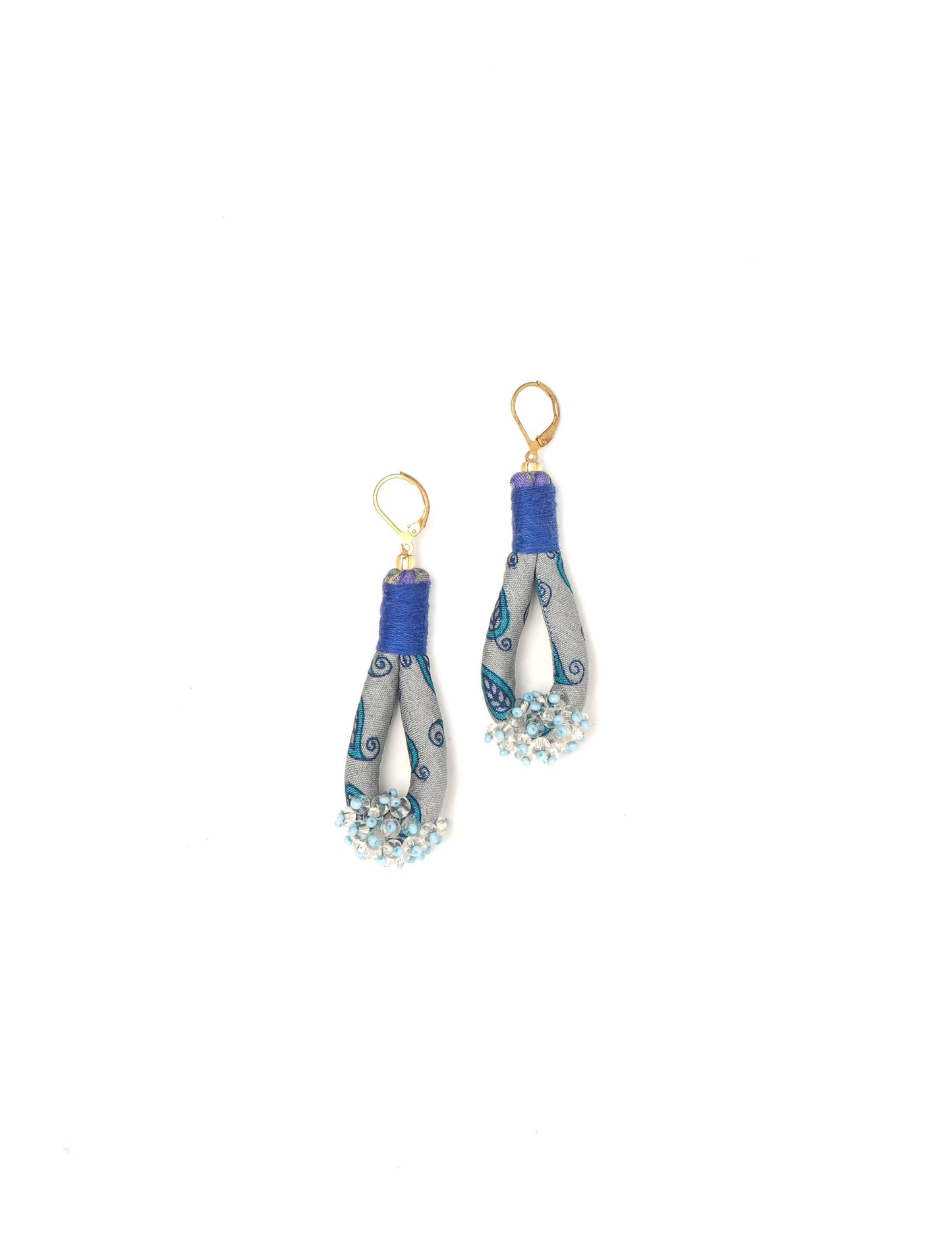 Discover the charm of Beaded Drop Earrings, meticulously crafted by Indian artisans. Recycled cotton rope, sari fabric, and surplus glass beads create an eco-friendly masterpiece. Hypoallergenic metal hooks ensure both style and comfort.